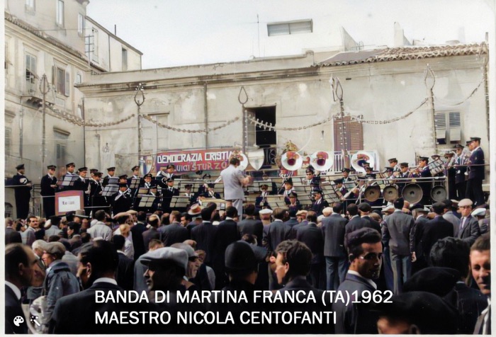 Sul palco di una piazza, 1962: la banda di Martina Franca diretta dal maestro Nicola Centofanti (fotografia colorata digitalmente).