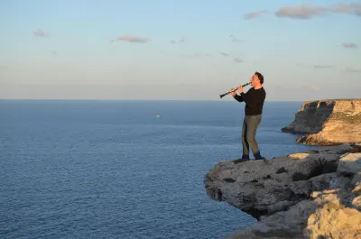 Un clarinettista sulla scogliera, al tramonto – Scatto artistico – Puglia (costa)